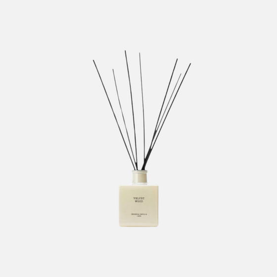 Citrine Home Velvet Wood reed diffuser in a square cream glass bottle with black reeds against a plain background