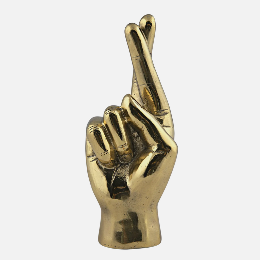 Citrine Home fingers crossed hand sculpture in handcrafted antiqued brass with a polished finish on black background