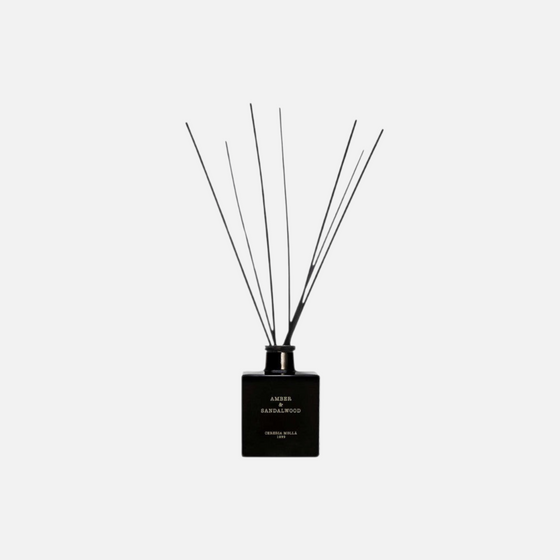 Citrine Home Amber & Sandalwood reed diffuser in a sleek black glass bottle with black reeds for home fragrance