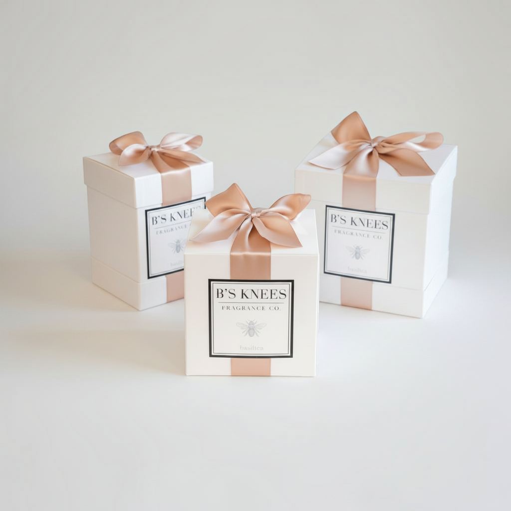 Citrine Home Basilica fragrance gift boxes in white with elegant champagne satin ribbons on a neutral background.