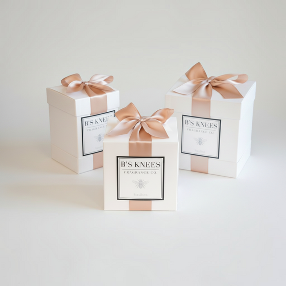 Citrine Home Basilica fragrance gift boxes in white with elegant champagne satin ribbons on a neutral background.
