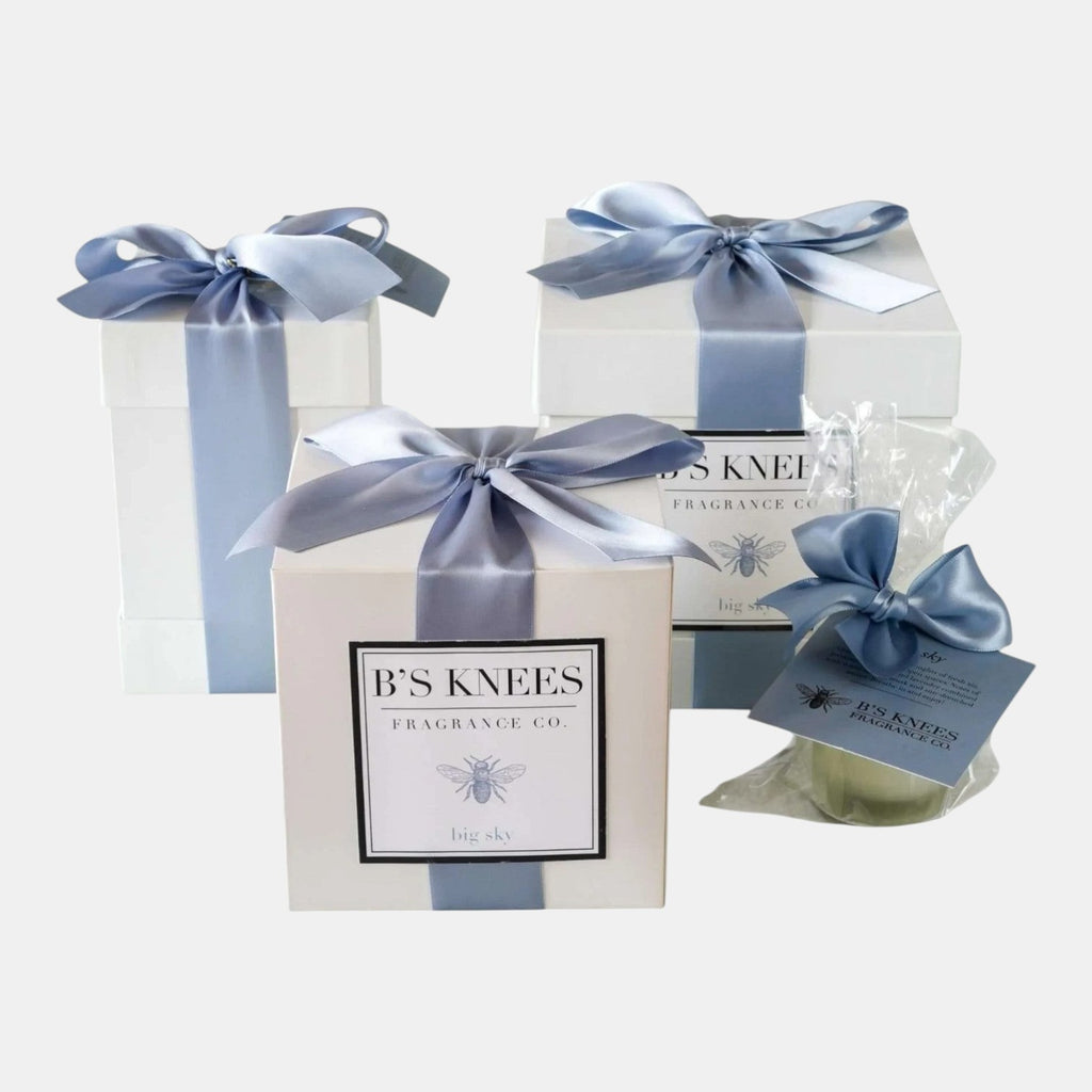 Citrine Home Big Sky fragrance gift set featuring white boxes with blue satin bows and B's Knees Fragrance Co. labels.