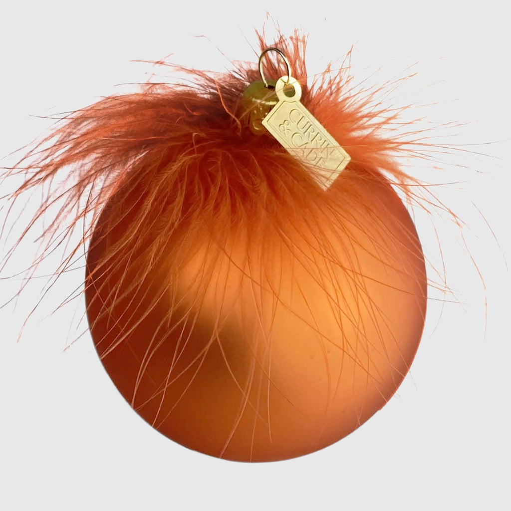Citrine Home butterscotch mouth-blown glass ornament decorated with delicate orange feathers and a gold brand tag.
