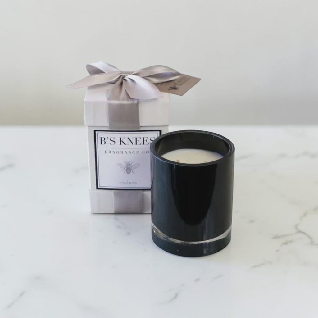 Citrine Home Embers black two-wick candle in a glass jar next to its gift box with a grey ribbon on a marble surface
