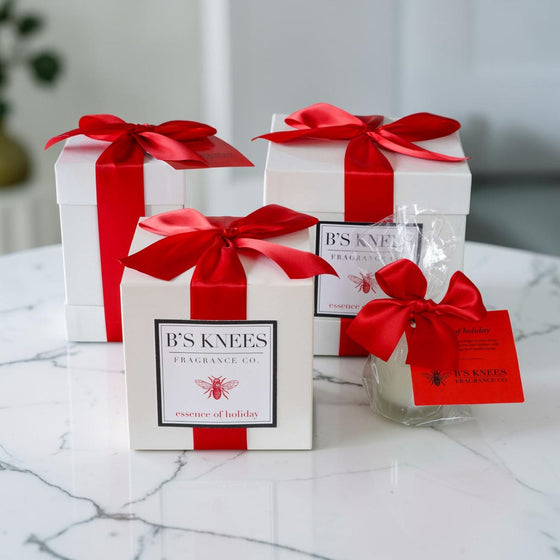 Citrine Home Essence of Holiday 2-wick candle gift sets in white boxes with red ribbons on a marble table