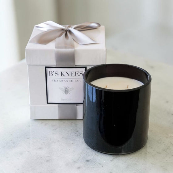 Citrine Home Fireside scented candle in a sleek black glass jar next to a white gift box with a silver ribbon.