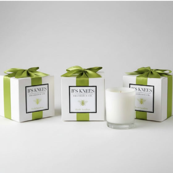 Citrine Home Fresh Bamboo scented candle in a glass jar with three white gift boxes tied with green satin ribbons.