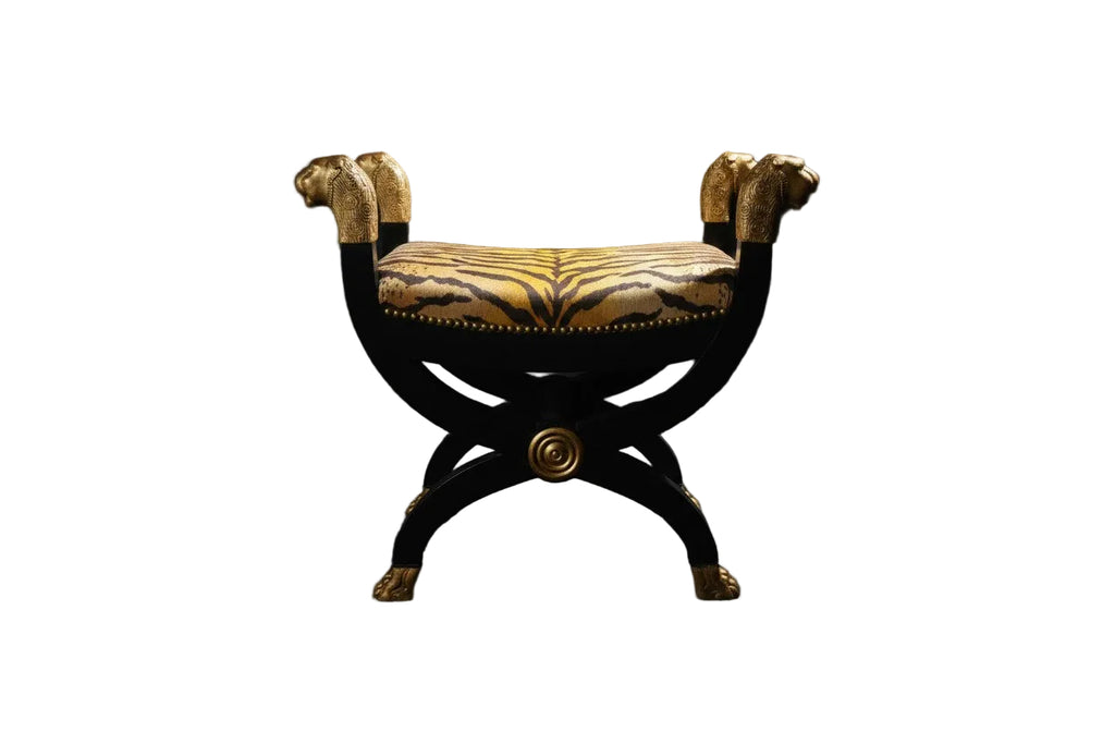 Citrine Home neoclassical curule bench with black wood frame, gilt lion head accents, and tiger print upholstered seat.