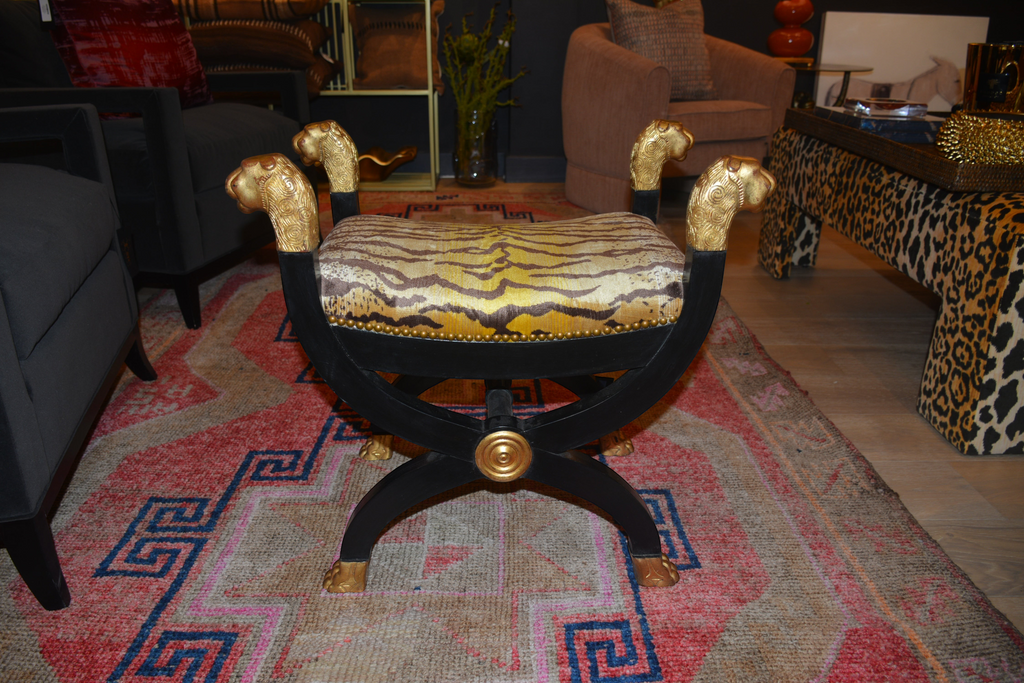 Citrine Home neoclassical curule bench featuring black wood, gold lion head accents, and tiger print upholstery.