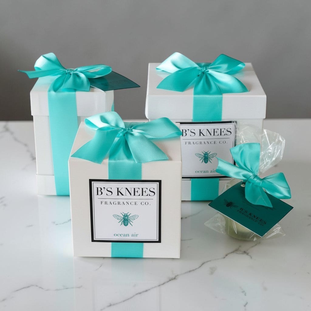 Citrine Home Ocean Air fragrance gift set featuring white boxes with teal satin ribbons and bee logo labels