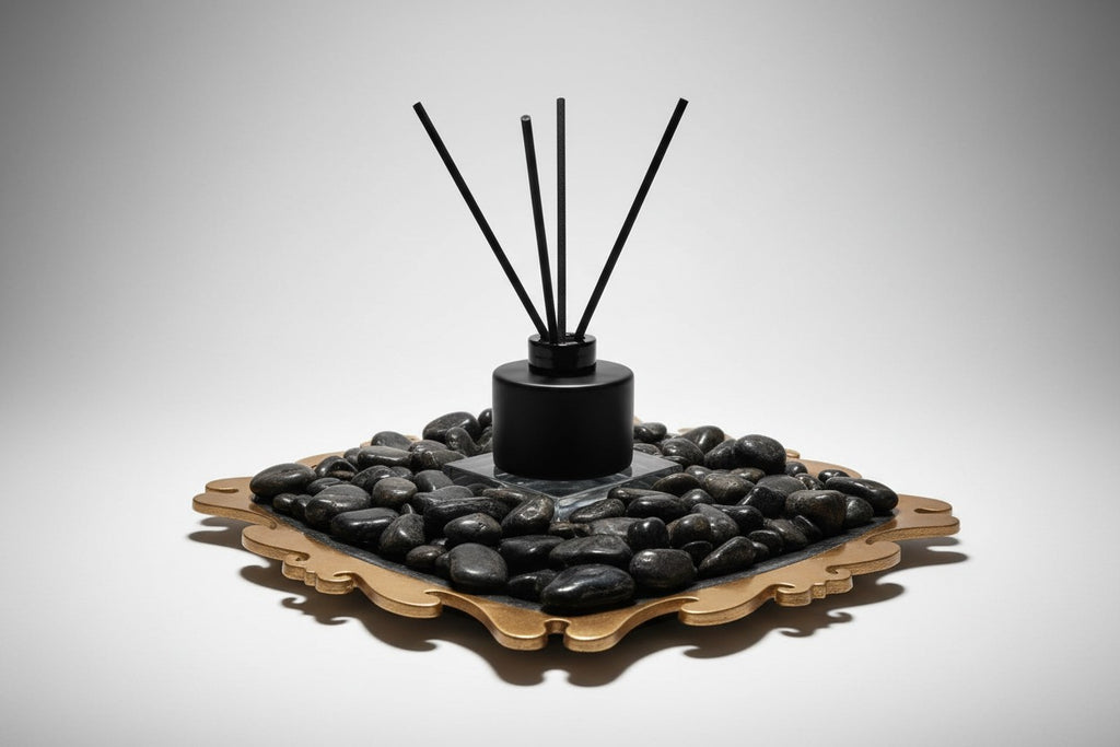 Citrine Home Onyx reed diffuser with black bottle and reeds set on a decorative gold tray with black river stones.
