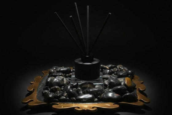 Citrine Home Onyx reed diffuser featuring black reeds and stones on a decorative gold-toned tray against a black background