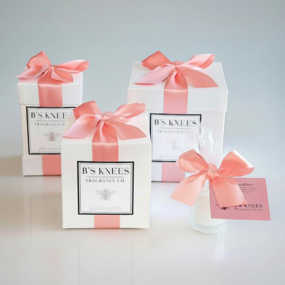Citrine Home Pink Grapefruit scented candle gift set in white boxes with pink satin ribbons and a small glass votive.