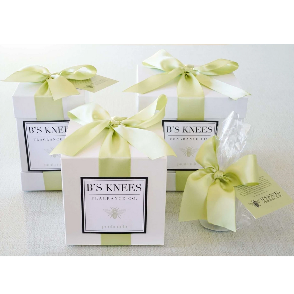 Citrine Home Punta Mita fragrance gift boxes with white packaging, light green satin ribbons, and bee logo branding.