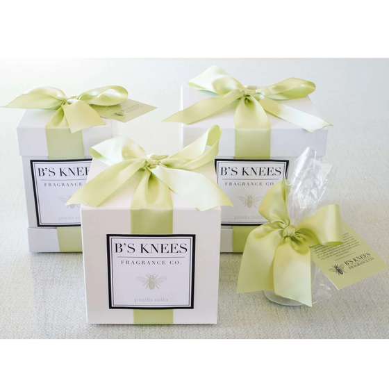 Citrine Home Punta Mita fragrance gift boxes with white packaging, light green satin ribbons, and bee logo branding.