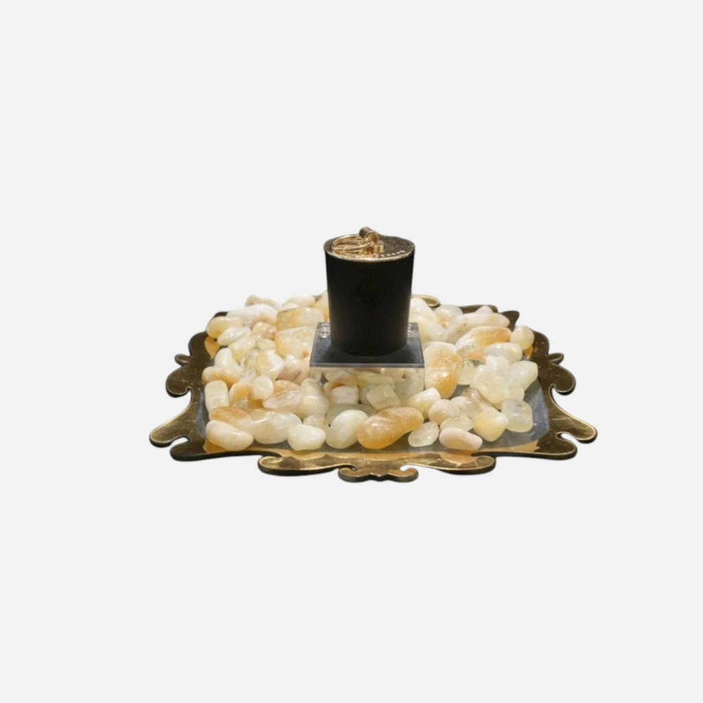 Citrine Home 8 oz Saffron Tobacco candle in a black jar resting on a decorative tray with polished citrine stones