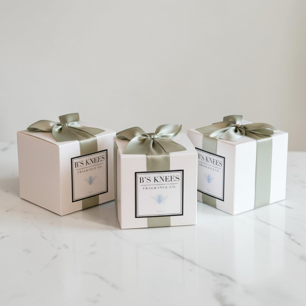 Citrine Home Spa fragrance gift boxes in white packaging with sage green ribbons on a white marble surface