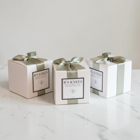 Citrine Home Spa fragrance gift boxes in white packaging with sage green ribbons on a white marble surface