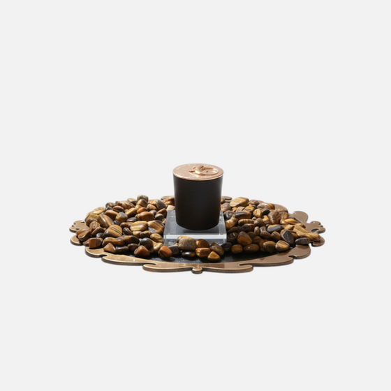 Citrine Home Tiger's Eye 8 oz candle in a black jar, displayed on a decorative tray surrounded by tiger's eye stones.